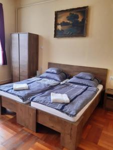 a large bed with two pillows on top of it at Helga Apartman in Makó