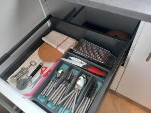 un cassetto pieno di utensili da cucina in un armadietto di Jolie F2 à 5mn de l'aéroport d'Orly a Paray-Vieille-Poste