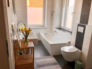 uma casa de banho com um WC, uma banheira e um lavatório. em Atelier Loft Bürgel em Bürgel