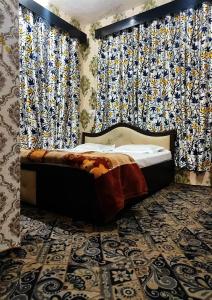 ein Schlafzimmer mit einem Bett in einem Zimmer mit Vorhängen in der Unterkunft Fabulous Kashmir Srinagar in Srinagar