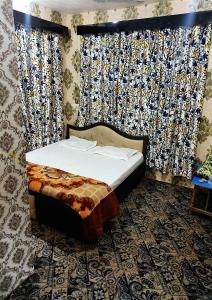 Bett in einem Zimmer mit Fenster und Vorhängen in der Unterkunft Fabulous Kashmir Srinagar in Srinagar