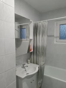 uma casa de banho branca com um lavatório e um espelho em Apartman VOZIC em Brcko
