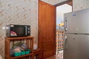 eine Küche mit einer Mikrowelle und einem Kühlschrank in der Unterkunft Face Nal in Douala