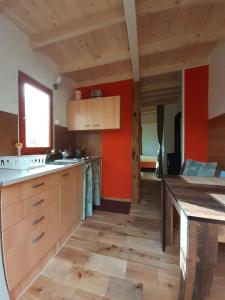 eine Küche mit roten Wänden und Holzböden in der Unterkunft Casetta-Felicita in Bossolasco