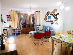 a living room with a blue couch and red chairs at Marina Esuri Golf y Playa in Ayamonte