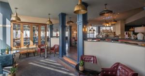 un restaurant avec un bar doté de chaises et de tables dans l'établissement Metro Apartments Dublin Airport, à Dublin