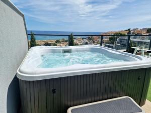 a hot tub on a balcony with a view of the ocean at CASCADA del MAR I - GRAN ALACANT in Gran Alacant