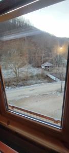 Blick auf ein schneebedecktes Feld aus dem Fenster in der Unterkunft Apartmani Prica in Crni Vrh