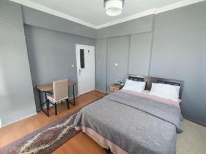 a bedroom with a bed and a table and a desk at 3+1 daire.hızlı Wifi,havalimanı plaj, market yakın in Antalya