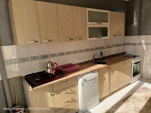 a kitchen with wooden cabinets and a counter top at 3+1 daire.hızlı Wifi,havalimanı plaj, market yakın in Antalya