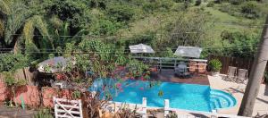 a swimming pool in a yard with a table and chairs at Pousada Beira Rio Cipó in Serra do Cipo