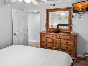 a bedroom with a bed and a mirror on a dresser at IS9-Cozy Upstairs Beachfront Condo - King Beds in Fort Walton Beach