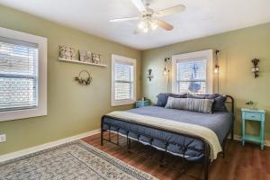 Un dormitorio con una cama con ventilador de techo. en A Bended Oak Bungalow, en Galveston