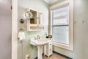 baño blanco con lavabo y ventana en A Bended Oak Bungalow, en Galveston 19 fotos más