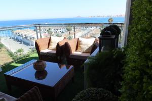 balkon z 2 krzesłami i stołem z widokiem na plażę w obiekcie EL REMANSO IV w mieście La Manga del Mar Menor