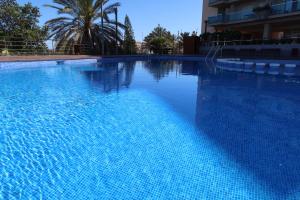 een groot blauw zwembad naast een gebouw bij EL REMANSO IV in La Manga del Mar Menor