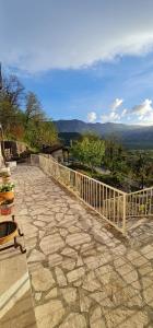 a stone patio with a fence and a view of the mountains at Dembelija Rooms in Virpazar