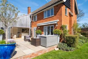 an extension to a brick house with a patio at Winton Lodge in Aldeburgh