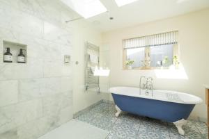 a bathroom with a blue tub and a shower at Winton Lodge in Aldeburgh
