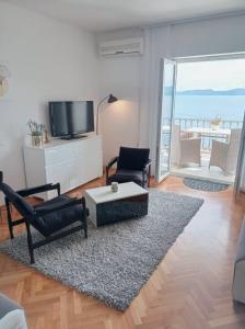 a living room with a television and a table and chairs at Apartments Mirko in Mimice