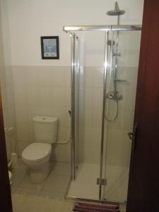 a bathroom with a toilet and a glass shower at Casa Valente in Macedo de Cavaleiros