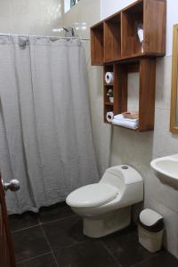 La salle de bains est pourvue de toilettes blanches et d'un lavabo. dans l'établissement Casa Montero, acogedora y amplia. Iquitos-Peru, à Iquitos