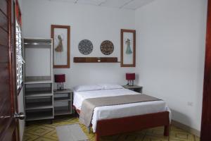 1 dormitorio con 1 cama y 3 cuadros en la pared en Casa Montero, acogedora y amplia. Iquitos-Peru, en Iquitos