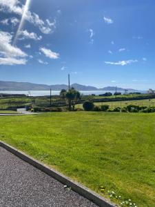 a field of green grass next to a road at Bungalow by the sea 