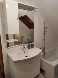 a white bathroom with a sink and a bath tub at MARIA in Varaždin