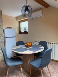 a table with chairs and a bowl of fruit on it at MARIA in Varaždin