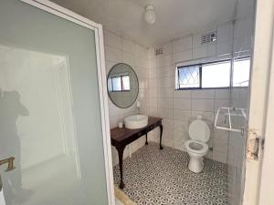 a bathroom with a toilet and a sink and a mirror at Safi Classic 3 bedroom Apartment 4 in East London