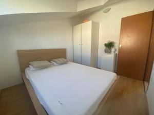 ein Schlafzimmer mit einem großen weißen Bett in einem Zimmer in der Unterkunft Sunny Apartment in Srima