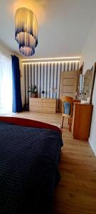 een slaapkamer met een bed en een kroonluchter bij Marine Apartament in Gdańsk