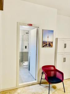 une chaise rouge dans une pièce avec un miroir dans l'établissement Smart Design Apartment Central Station, à Bergame