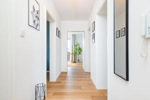 un pasillo de una casa con paredes blancas y suelo de madera en E&K living - design apartment - 2 bedrooms - kitchen - free parking, en Augsburg