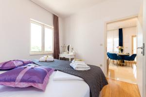 a bedroom with a large bed with purple sheets at Luxa 5 min old town, 10 min airport in Trogir