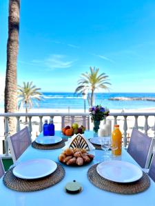 a blue table with food and a view of the beach at Puerto Banús Beach Apartments in Marbella