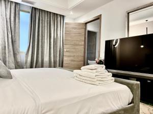 a bedroom with a bed with white towels on it at Puerto Banús Beach Apartments in Marbella