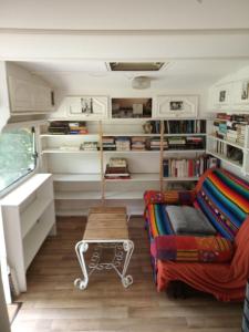 a room with a bed and a couch and shelves at Hébergement insolite nature/4 in Saint-André-de-Sangonis