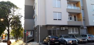 a building with cars parked in front of it at Apartman A1 in Bijeljina