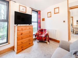 a living room with a tv and a dresser with a television at Piglets House - Uk43488 in Aldington