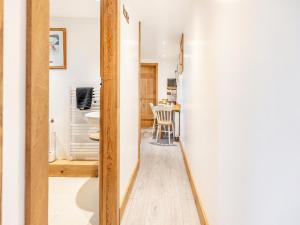 pasillo que conduce a un baño con mesa y sillas en Piglets House - Uk43488 en Aldington