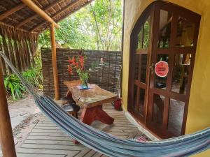 a hammock on a porch with a table and a door at Nova Gaia Algodões in Marau