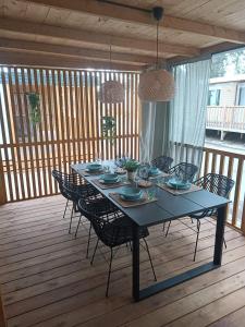 une table bleue avec des chaises sur une terrasse en bois dans l'établissement Ana Mobile Home - Kamp Soline - Biograd na Moru, à Biograd na Moru