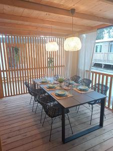 mesa de comedor y sillas en una terraza de madera en Ana Mobile Home - Kamp Soline - Biograd na Moru en Biograd na Moru