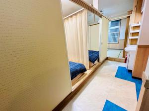 MoRi House IN 伊勢佐木町 في يوكوهاما: غرفة صغيرة بها سرير ومرآة