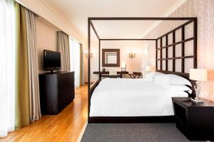 a bedroom with a large white bed and a television at Sheraton Rhodes Resort in Ixia