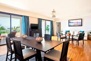 a living room with a dining room table and chairs at Sheraton Rhodes Resort in Ixia