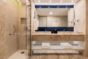 a bathroom with a shower and a sink and a mirror at Sheraton Rhodes Resort in Ixia