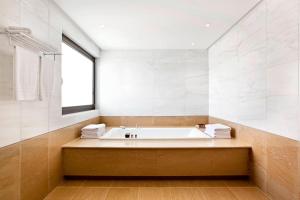 a large bathroom with a tub and a window at Sheraton Rhodes Resort in Ixia